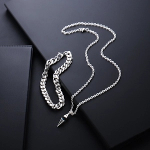 Close-up of silver star pendant necklace and cuban link bracelet on black texture