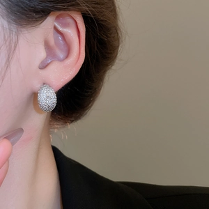 Detailed view of silver moon stud earrings with zircon inlay worn by a female model