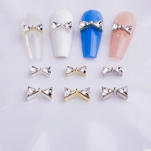 Bowtie nail art charms with K9 crystals on gold and silver metal bases for manicure