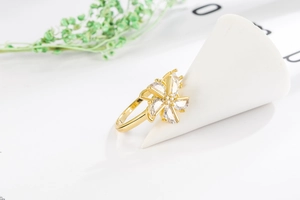 Detailed view of the rotating gold windmill flower ring inlaid with clear zircons