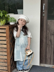 Détail de la robe patchwork à carreaux bleus avec t-shirt blanc et mini sac à main