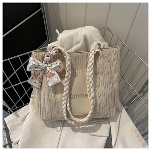 Détail du sac cabas en paille tissée avec patch Summer et poignée en foulard de soie