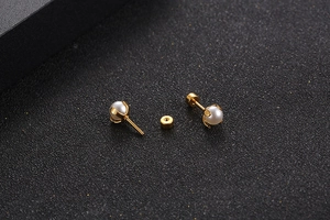 Detailed macro shot of gold pearl stud earrings featuring a secure screw-back design