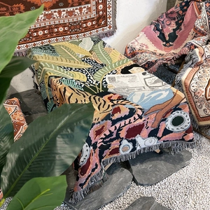 Close-up of bohemian woven throw with tiger pattern, vintage art, and tassel details