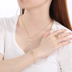 Elegant gold flower jewelry set with necklace and ring on a model with white background