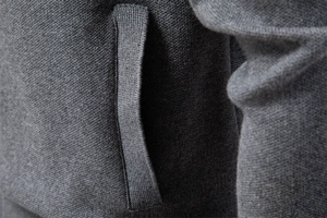Close-up of fine knit texture and side pocket detail on a dark grey cardigan jacket