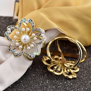 Macro detail of golden rose napkin ring with white pearls and sparkling rhinestones