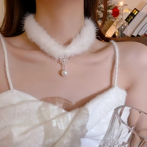 Gros plan sur un ras-du-cou blanc en peluche avec pendentif flocon et perle sur cou