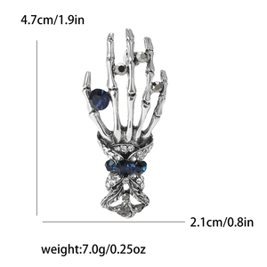 Detailed view of punk skeleton hand brooch with size dimensions and blue rhinestone