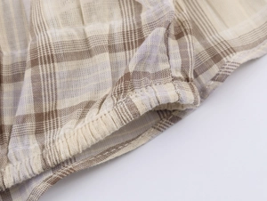 Détail du tissu à carreaux kaki avec poignet élastique et coutures de haute précision