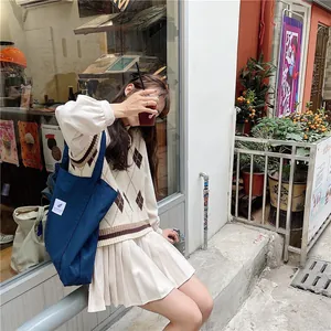 Navy canvas tote bag paired with vintage preppy knit vest and pleated skirt outfit