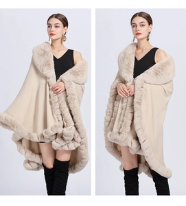 Detail of beige knit poncho featuring premium faux fur collar and trim texture