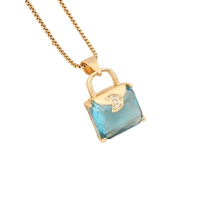 Elegant gold necklace featuring a blue crystal handbag pendant with zircon moon details