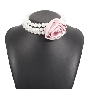 Detailed close-up of three-tier pearl choker necklace with a pink satin rose flower