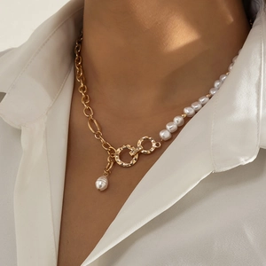 Detail of half-pearl half-gold chain necklace with water-drop pearl on white shirt