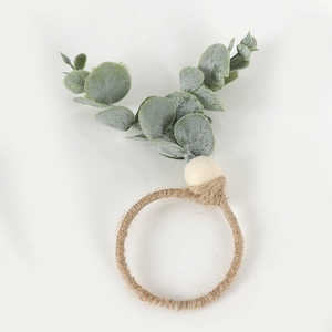 Close-up of eucalyptus napkin ring with jute rope, wooden beads, and frosted green leaves