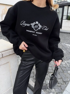 Detail of Royal Club graphic print and crown logo on black streetwear sweatshirt
