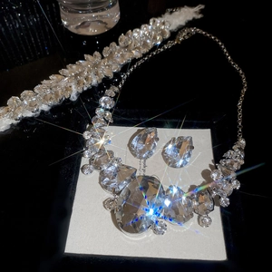 Detailed view of luxury silver-toned rhinestone teardrop necklace and earrings set in a gift box