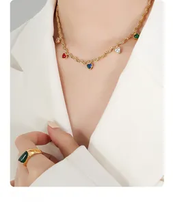 Close-up of golden rope chain necklace with colorful heart-shaped zircon pendants