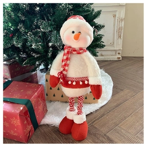 Close-up of plush snowman doll decoration with knitted scarf on a white cozy carpet