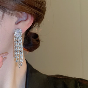 Close-up of dangling zircon tassel earrings with marquise cut stones and silver finish