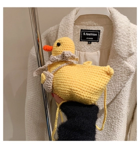 Close-up of yellow crochet duck bag showing dense knit texture and orange beak detail