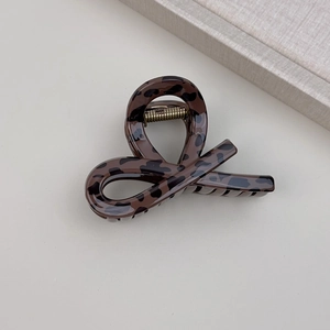 Detail of twisted leopard print hair claw clip in brown acetate with metal spring