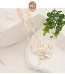 Close-up of baroque petal pearl necklace with intricate floral pendant and gold wire detail