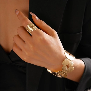 Macro detail of golden butterfly bracelet and ring set with textured wing engraving