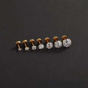 Detail view of seven sizes of shiny round zircon ear studs with golden prong settings