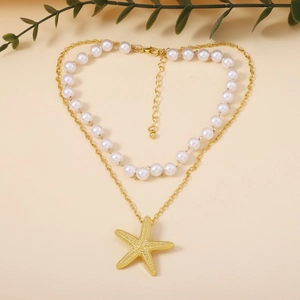 Detail of double-layer necklace with white faux pearls and a gold starfish pendant