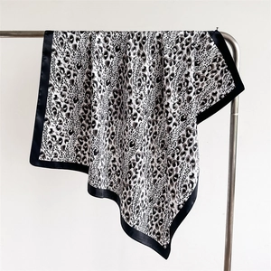 Detail of leopard print satin scarf showing smooth silk-like texture and black border