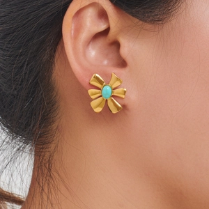 Golden flower earrings with turquoise center stone worn on a model for a stylish look