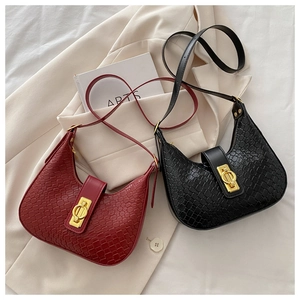 Detail of hobo crescent bags in black and wine red with crocodile pattern and gold buckles