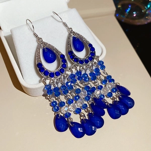 Detail view of vintage boho earrings with blue rhinestones and dangling bead tassels