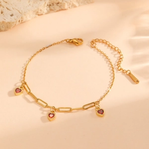 Bracelet en acier inoxydable plaqué or 18 carats avec trois pendentifs cœurs rouges