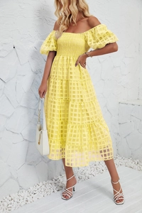Detail of yellow smocked bodice with puff sleeves and textured tiered skirt
