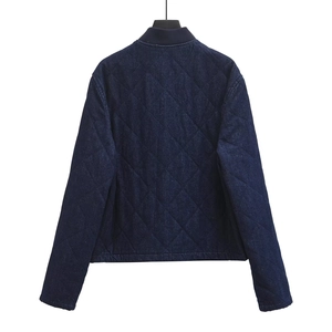Detail of dark blue quilted denim jacket featuring classic diamond stitching and ribbed collar