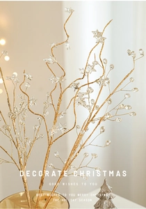 Golden Christmas decorative branches with transparent stars and warm festive lighting