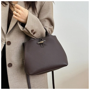 Detail of silver bamboo toggle closure on dark brown lychee textured leather mini bag