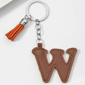 Detail of brown PU leather letter W keychain with orange suede tassel and silver hardware