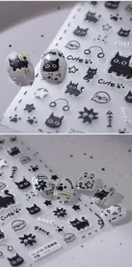 Close-up of 3D black cat nail art stickers featuring cute paw prints and fish bones