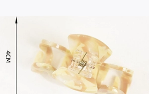 Detail shot of a 4cm acetate hair claw with marble texture and metal spring mechanism