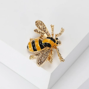 Macro detail of bee brooch with yellow enamel and sparkling rhinestones on wings