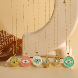 Detailed view of colorful Hamsa Hand and Evil Eye pendants on gold necklace chains