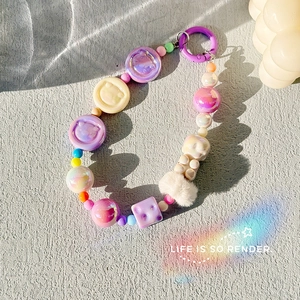 Detailed view of beaded charm with macaron resin bears and soft white plush balls