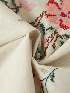 Détail de broderie florale sur tissu en coton et lin beige avec texture fine