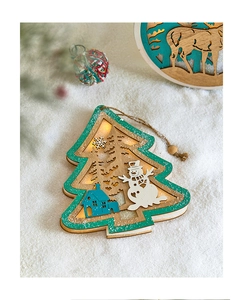 Close-up of lighted wooden Christmas tree pendant with reindeer and snowman cutouts