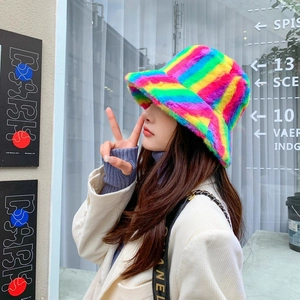 Detailed view of colorful plush bucket hat with rainbow faux fur stripes on model