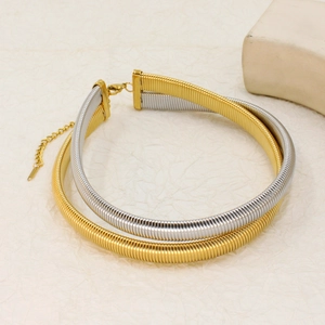 Detail of gold and silver snake chain necklaces with lobster clasp on beige texture